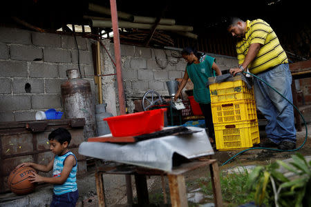 Leandro Colmenares en plena faena de fabricación de masa de maíz en el patio trasero de su casa en Caracas, Venezuela, el 3 de octubre de 2017. REUTERS/Carlos Garcia Rawlins