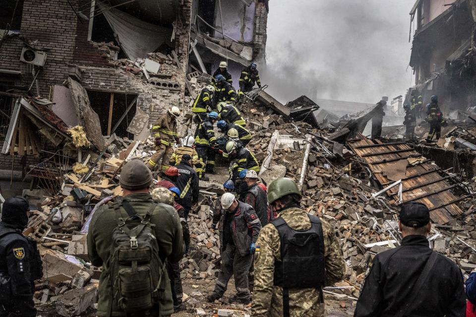 ZAPORIZHZHIA, UKRAINE - OCTOBER 10: Firefighters remove a dead body from debris of a building after Russian missile attack in Zaporizhzhia, Ukraine on October 10, 2022. Today, the head of the city's military administration Oleksandr Starukh, reported to the Ukrinform Ukrainian news agency that a multi-storey building was destroyed as a result of a new rocket attack on the city center of Zaporizhzhia. (Photo by Jose Colon/Anadolu Agency via Getty Images)