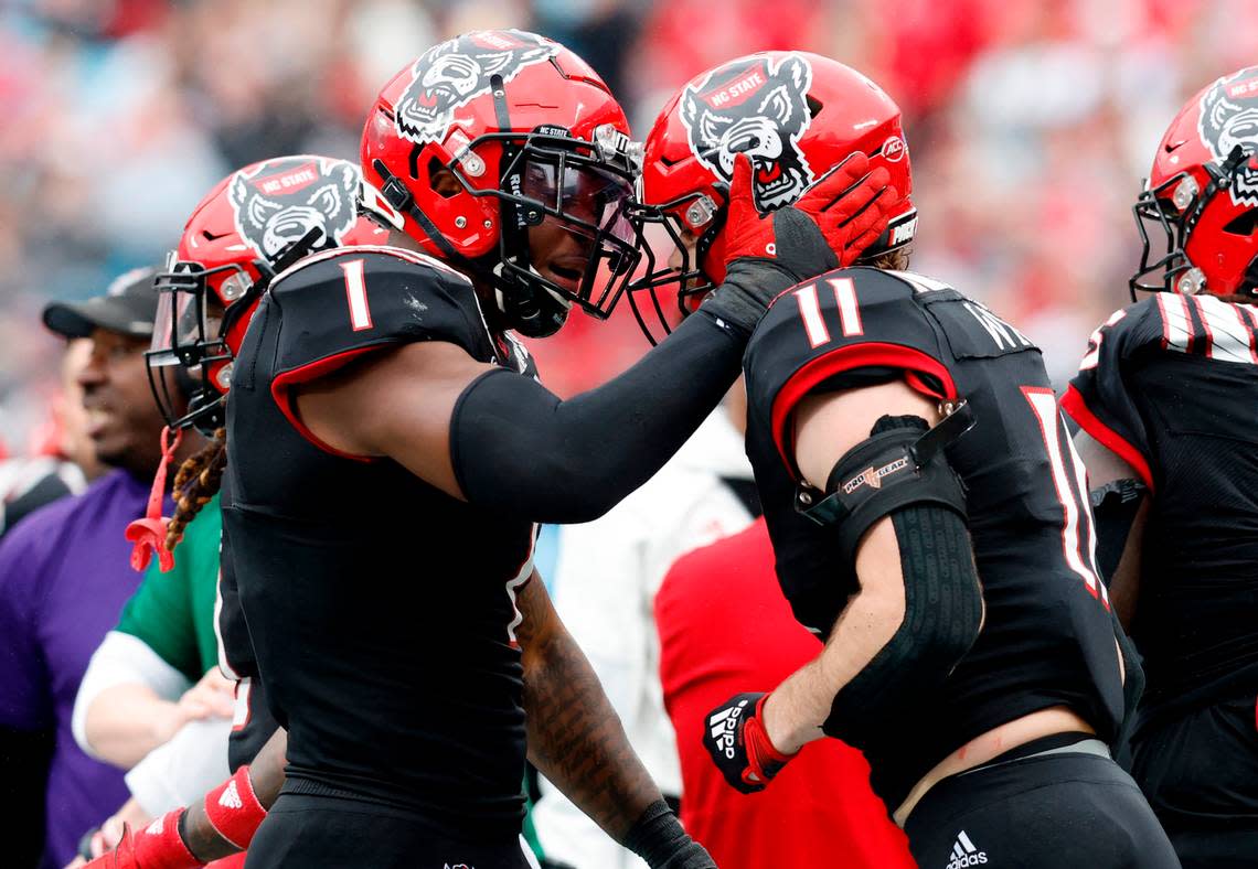 N.C. State’s Isaiah Moore (1) celebrates with Payton Wilson (11) after Wilson forced Maryland quarterback Taulia Tagovailoa (3) out of bounds during the first half of N.C. State’s game against Maryland in the Duke’s Mayo Bowl at Bank of America Stadium in Charlotte, N.C., Friday, Dec. 30, 2022.