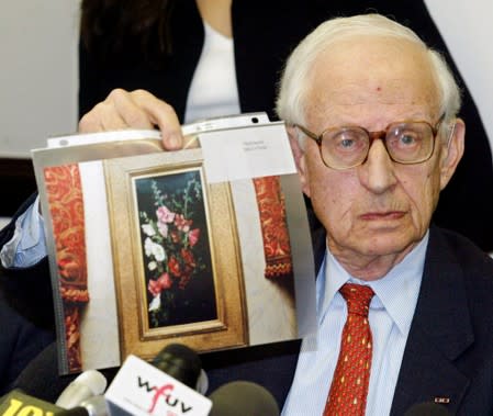 FILE PHOTO - Manhattan District Attorney Robert Morgenthau displays a photo of the painting "Hollyhocks" by John LaFarge at a press conference in New York