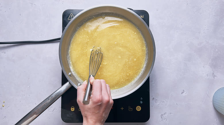 whisking turkey stock in skillet