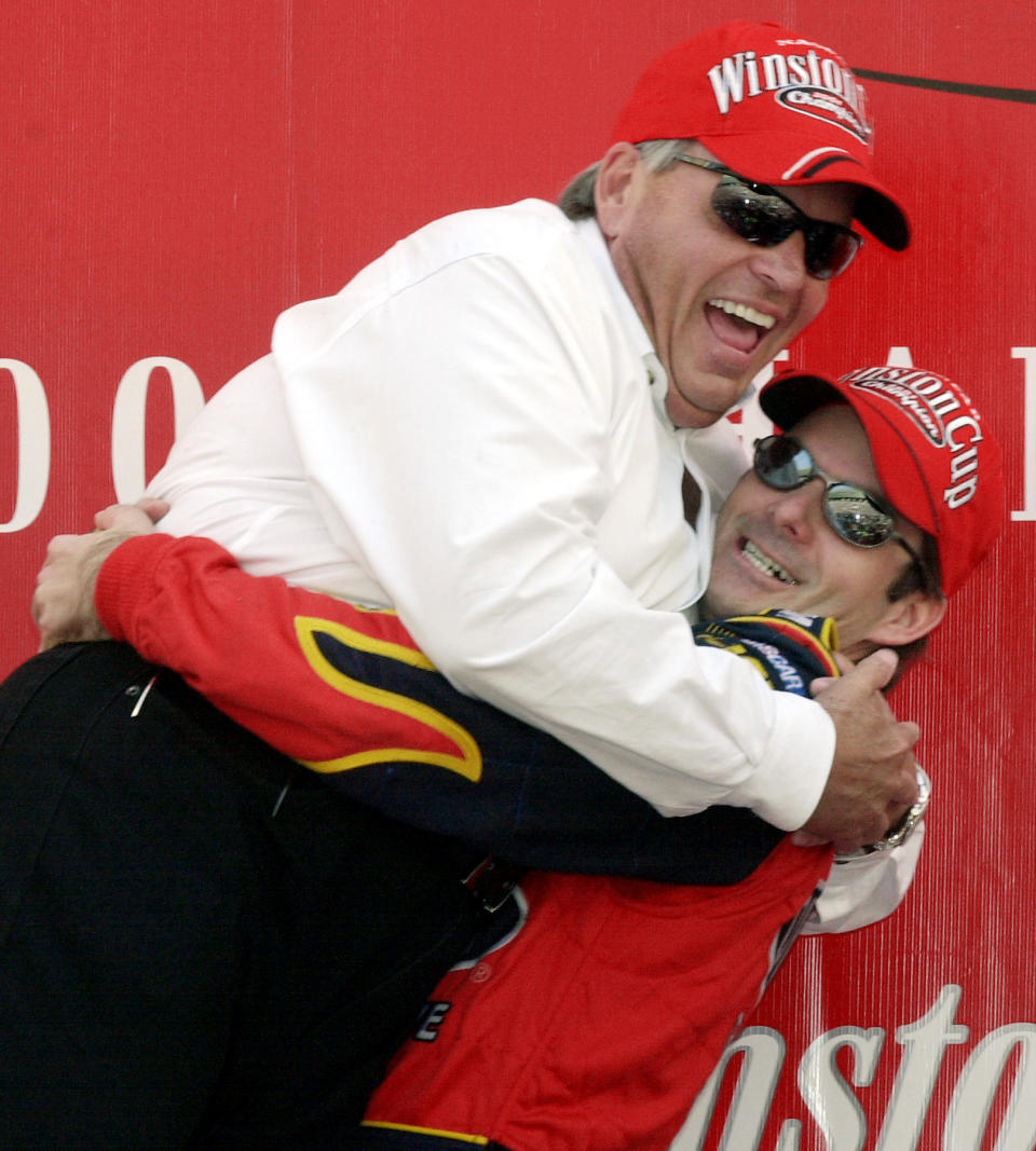 FILE - Winston Cup Champion Jeff Gordon, right, picks up car owner Rick Hendrick in Victory Lane after winning the Winston Cup at the NAPA 500 at Atlanta Motor Speedway in Hampton, Ga., Sunday, Nov. 18, 2001. Rick Hendrick and Hendrick Motorsports are marking the 40th anniversary of NASCAR’s winningest team. (AP Photo/Ric Feld, File)