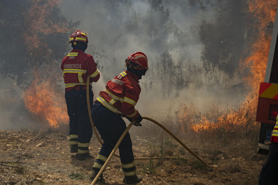 Firefighters try to extinguish a wildfire near Colos village, in central Portugal on Monday, July 22, 2019. More than 1,000 firefighters battled Monday in torrid weather against a major wildfire in Portugal, where every summer forest blazes wreak destruction. (AP Photo/Sergio Azenha)