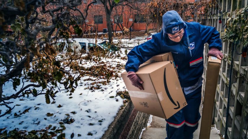 United States Postal Service worker Missie Kittok, who has been a letter carrier for 15 months, help