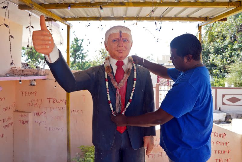 FILE PHOTO: Bussa Krishna, a fan of U.S. President Donald Trump, adjusts a garland on a Trump statue after offering prayers at his house in Konney village