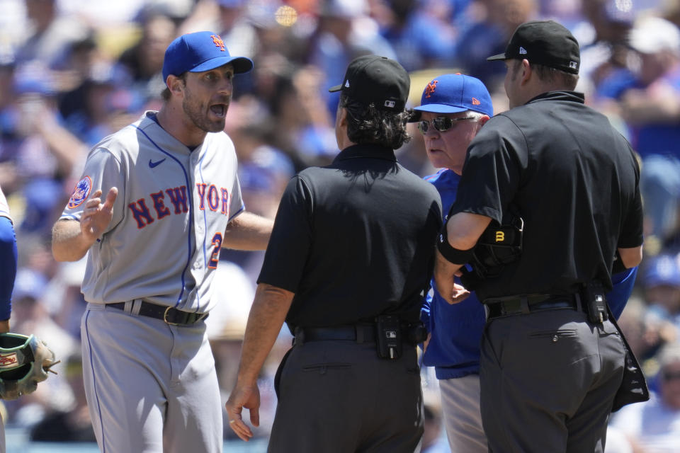 New York Mets starting pitcher Max Scherzer (21) and manager Buck Showalter dispute a call from umpire Phil Cuzzi, center, and umpire Dan Bellino, right, after they found a problem with Scherzer's glove during the fourth inning of a baseball game in Los Angeles, Wednesday, April 19, 2023. Scherzer was ejected from the game. (AP Photo/Ashley Landis)