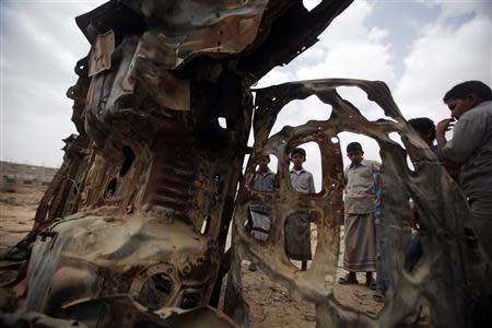 Boys gather near the wreckage of a car destroyed in 2012 by a U.S. drone air strike targeting suspected al Qaeda militants in Azan, in the southeastern Yemeni province of Shabwa, in this February 3, 2013 file photo. REUTERS/Khaled Abdullah/Files