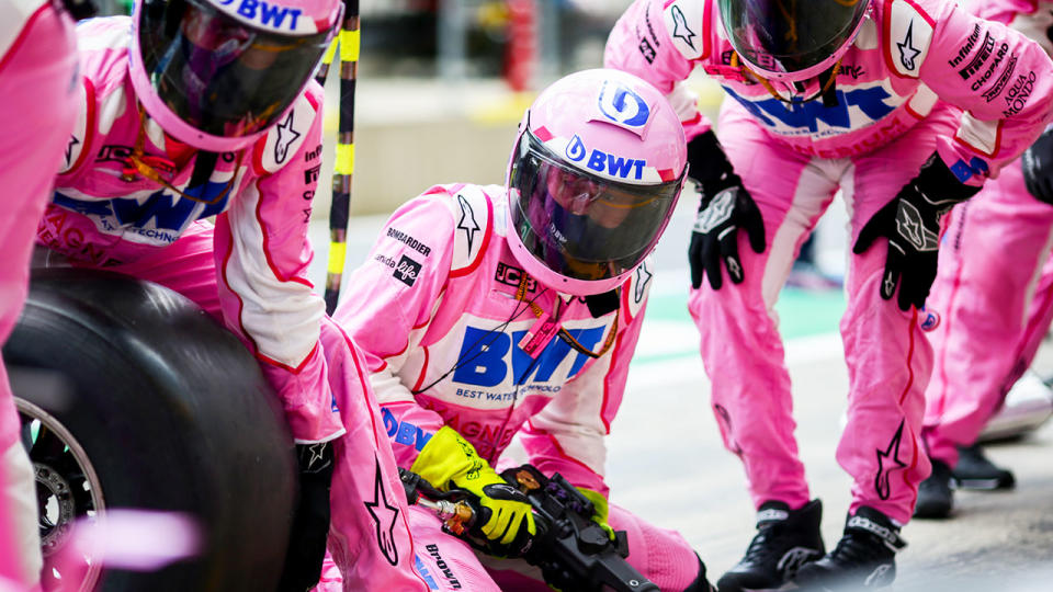 Seen here, Racing Point mechanics get ready to perform a tyre change.