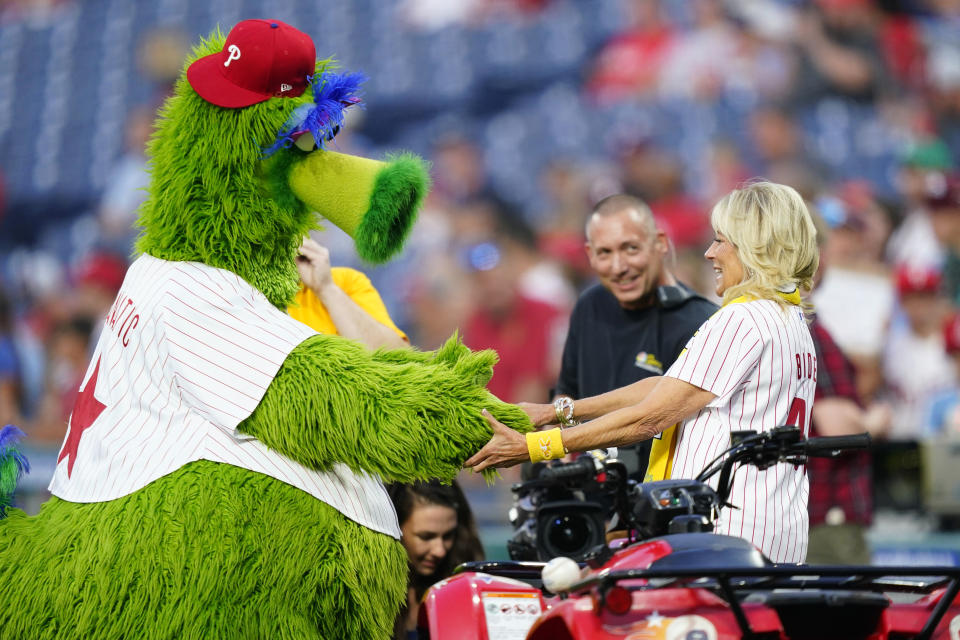 FILE - First lady Jill Biden greets the Phillie Phanatic mascot after participating in the Philadelphia Phillies' sixth annual "Childhood Cancer Awareness Night" before a baseball game against the Washington Nationals, Sept. 9, 2022, in Philadelphia. (AP Photo/Matt Slocum, File)