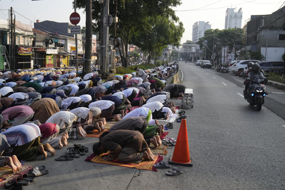 Muslim men perform Eid al-Fitr prayer marking the end of the holy fasting month of Ramadan, on a street outside an overflowed mosque in Jakarta, Indonesia, Monday, May 2, 2022. (AP Photo/Dita Alangkara)