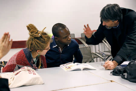 A migrant converses with a teacher during Italian language classes near the former Olympic village in Turin, Italy January 14, 2018. Picture taken January 14, 2018. REUTERS/Siegfried Modola