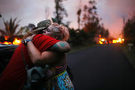 <p>Zivile Roditis hugs Howie Rosin (L), shortly after Roditis’ home was destroyed by lava from a Kilauea volcano fissure, in Leilani Estates, on Hawaii’s Big Island, on May 25, 2018 in Pahoa, Hawaii. (Photo: Mario Tama/Getty Images) </p>