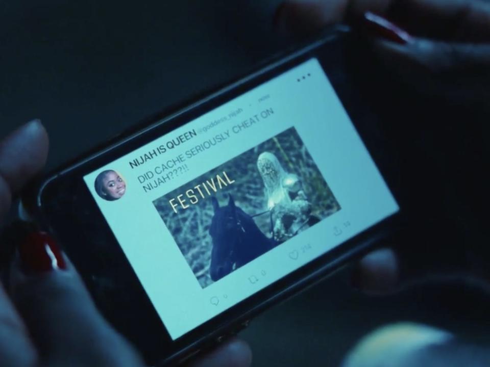 Dre looks at a tweet from a Ni'Jah fan speculating that Cache cheated on the singer in this still from "Swarm."