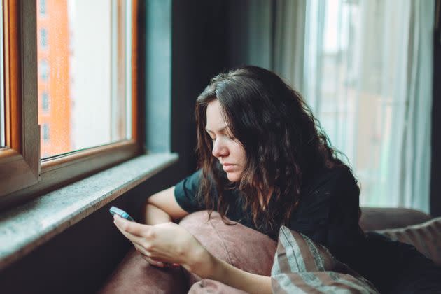 Depressed woman sitting on sofa at home