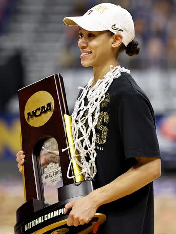 <p>Elsa/Getty</p> Anna Wilson with the championship trophy after the National Championship game of the 2021 NCAA Women's Basketball Tournament.