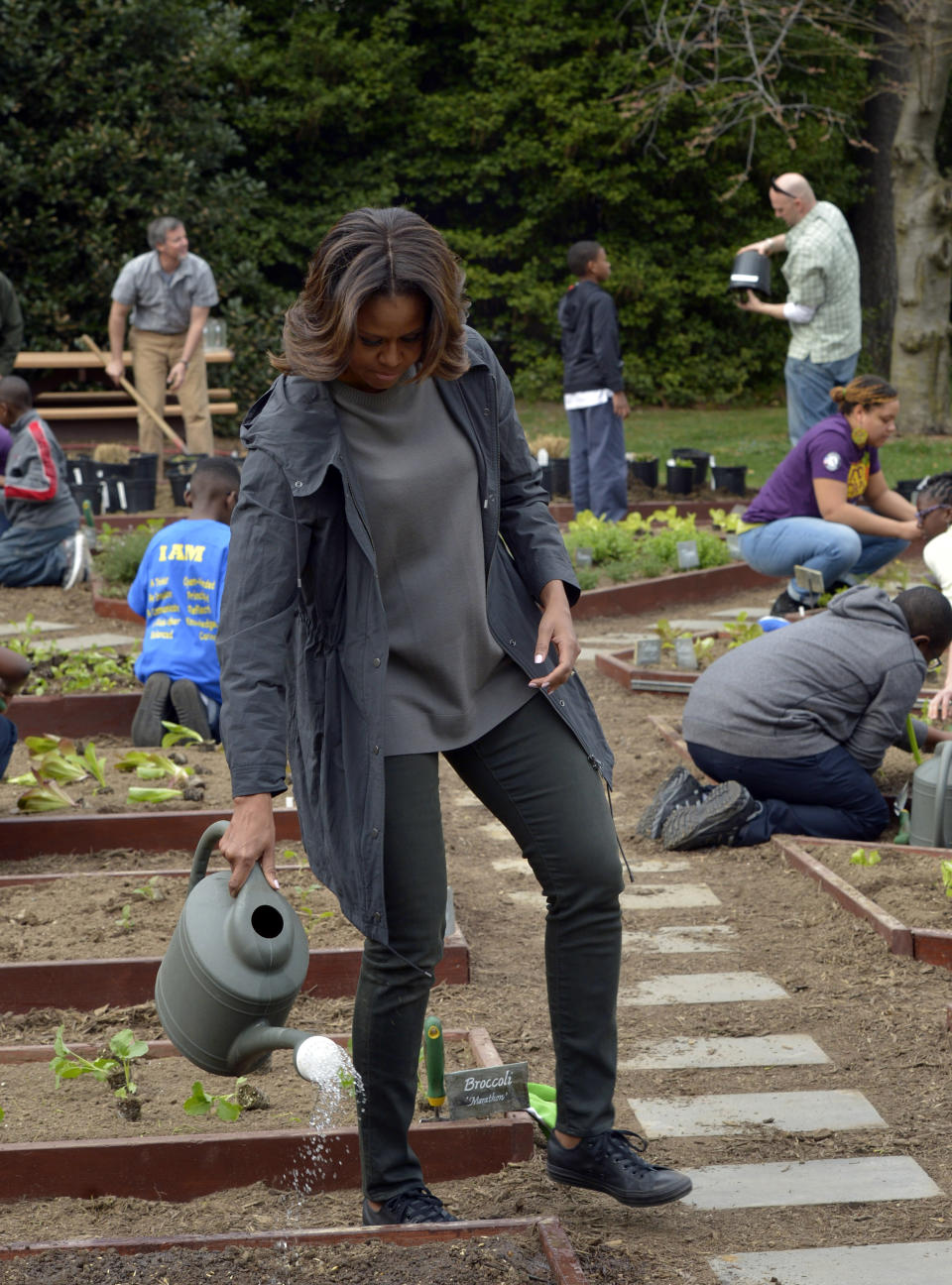 First lady Michelle Obama waters newly planted Lincoln oats after she and local-area students planted vegetables in the White House Kitchen Garden at the White House in Washington, Wednesday, April 2, 2014. (AP Photo/Susan Walsh)