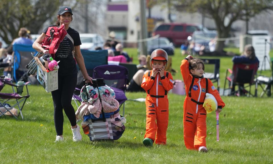 Lima, Ohio residents Shannon Sien and twins Mateo and Malania West look for a spot to view the 2024 Total Solar Eclipse at the Neil Armstrong Air & Space Museum in Wapakoneta, Ohio on April 8, 2024. Sien said they bought the orange jumpsuits at COSI in Columbus.