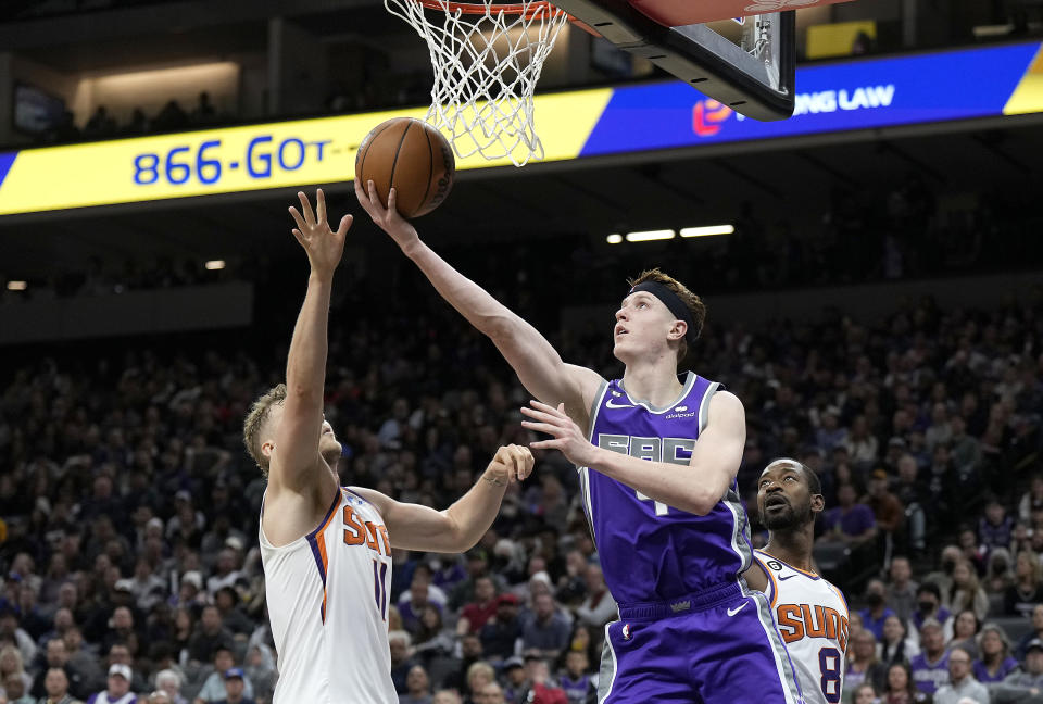 SACRAMENTO, CALIFORNIA - MARCH 24: Kevin Huerter #9 of the Sacramento Kings shoots a reverse layup over Jock Landale #11 of the Phoenix Suns during the third quarter at Golden 1 Center on March 24, 2023 in Sacramento, California. NOTE TO USER: User expressly acknowledges and agrees that, by downloading and or using this photograph, User is consenting to the terms and conditions of the Getty Images License Agreement. (Photo by Thearon W. Henderson/Getty Images)