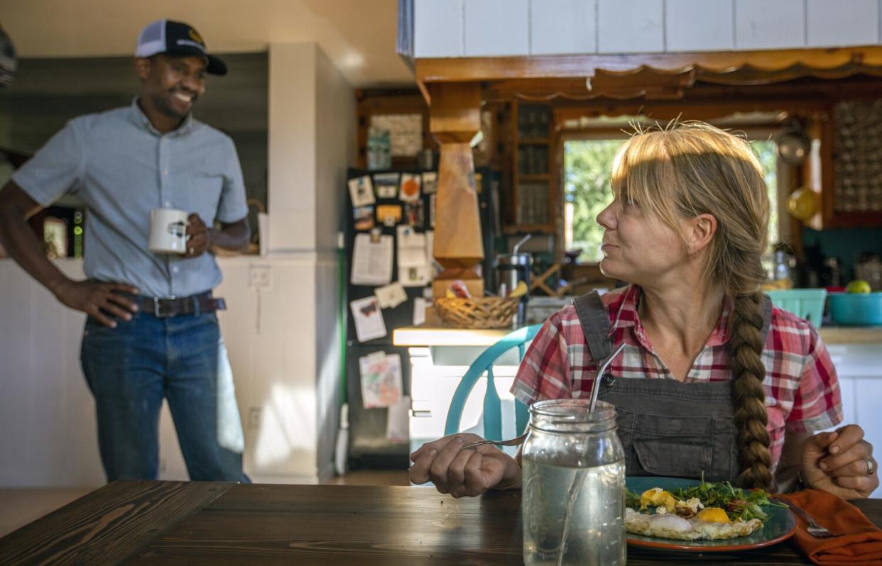 Andre Essue smiles at his wife, Kjessie, as she eats breakfast.