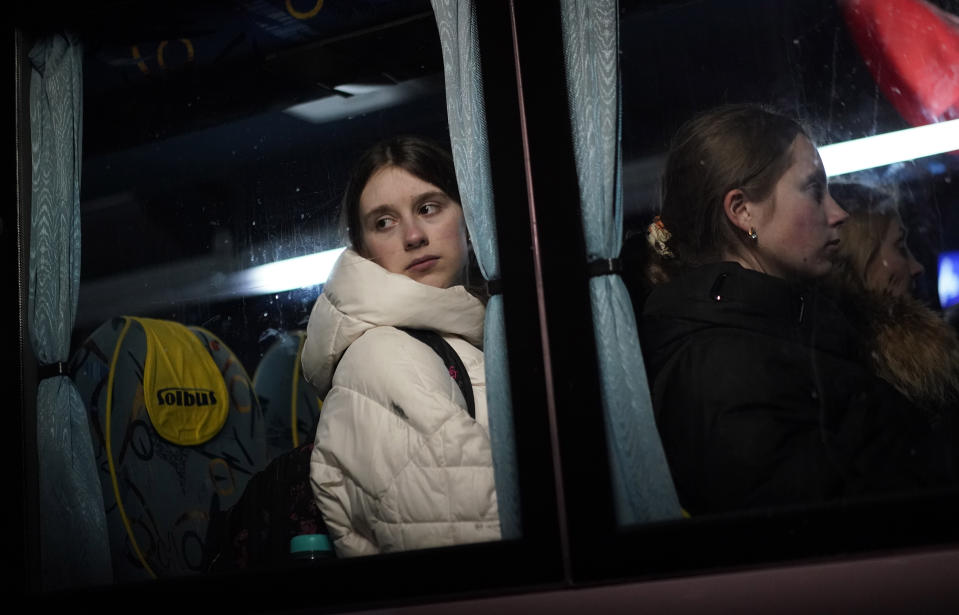 A young girl, who has fled Ukraine, looks out of the window of a bus as she prepares to travel to Przemysl after arriving at the border crossing in Medyka, Poland, Sunday, March 13, 2022. Now in its third week, the war has forced more than 2.5 million people to flee Ukraine. (AP Photo/Daniel Cole)