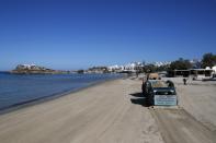 A tractor cleans Agios Georgios beach, on the Aegean island of Naxos, Greece, Wednesday, May 12, 2021. With debts piling up, southern European countries are racing to reopen their tourism services despite delays in rolling out a planned EU-wide travel pass. (AP Photo/Thanassis Stavrakis)