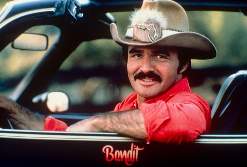 <p>Reynolds strikes a pose while dressed as his character from <em>Smokey and the Bandit</em> at a photoshoot in the '70s.</p>