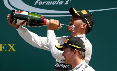 Formula One - F1 - British Grand Prix 2015 - Silverstone, England - 5/7/15 Mercedes' Lewis Hamilton celebrates his win on the podium with the champagne Reuters / Phil Noble