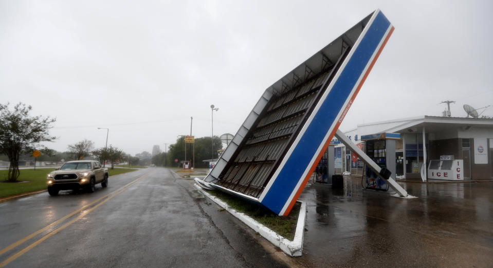 A vehicle passes a toppled gas pump canopy in Berwick, La., following a severe weather assault from Tropical Storm Barry, Saturday, July 13, 2019. (AP Photo/Rogelio V. Solis)