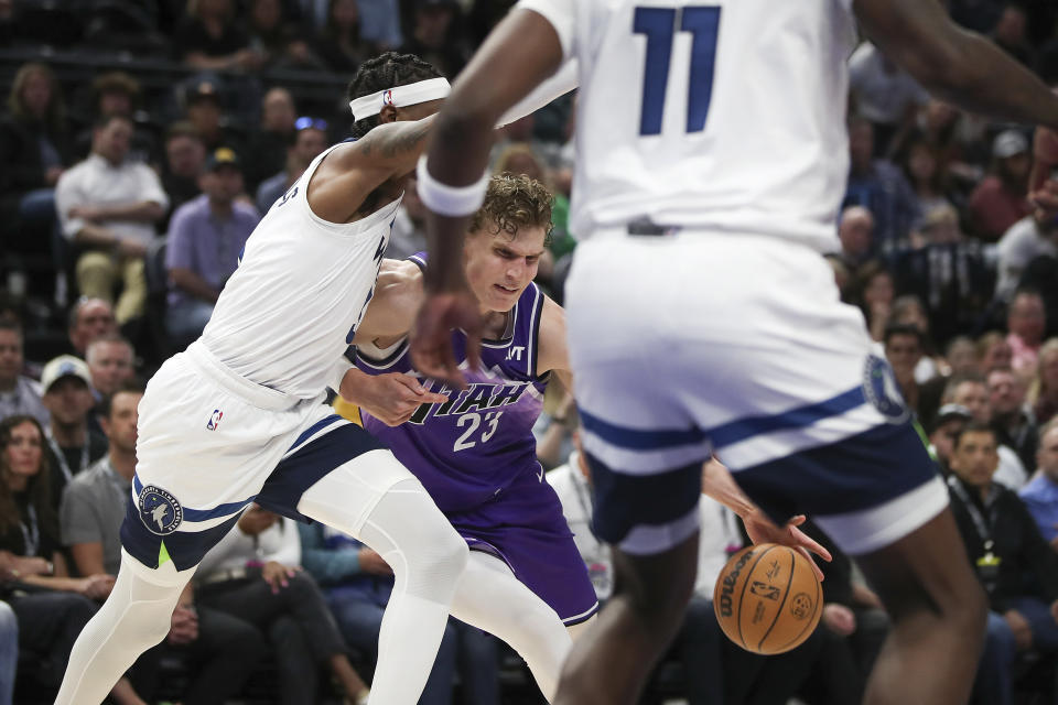 Utah Jazz forward Lauri Markkanen (23), center, dribbles through the defense of Minnesota Timberwolves forward Jaden McDaniels, left, and center Naz Reid (11) during the first half of an NBA basketball game Monday, March 18, 2024, in Salt Lake City. (AP Photo/Adam Fondren)