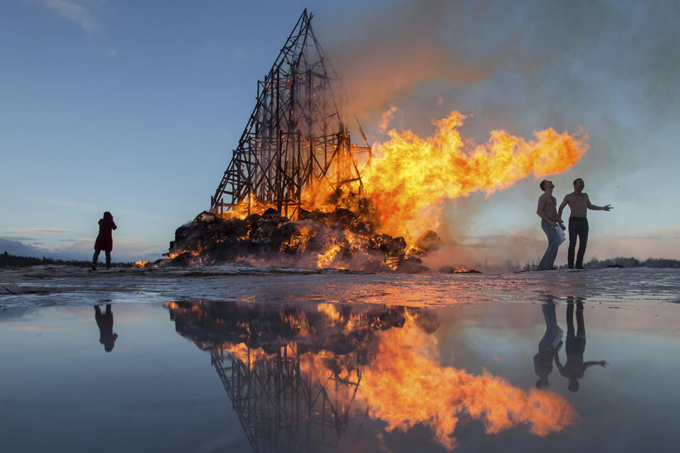 <p>People react as a sculpture is burning at the Maslenitsa festival at the Nikola-Lenivets art park in Nikola-Lenivets village, Russia, Feb. 25, 2017. As part of the celebrations of the “Butter Week”, or Maslenitsa in Russian, a folk holiday which heralds the beginning of spring, contemporary artist and park founder Nikolay Polissky built a giant sculpture made of wood and hay which was burned to ashes in a traditional bonfire. (Photo: Denis Tyrin/AP) </p>