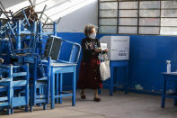 A woman wearing a mask to curb the spread of the new coronavirus carries her marked ballot during general elections at the Villa El Salvador neighborhood in Lima, Peru, Sunday, April 11, 2021. (AP Photo/Guadalupe Pardo)