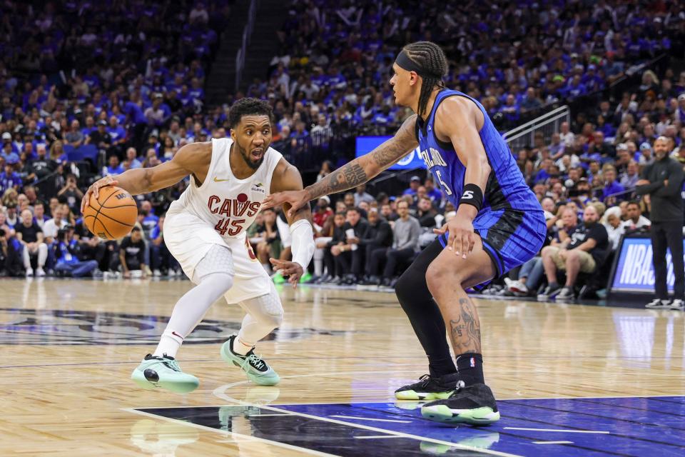 Cavaliers guard Donovan Mitchell handles the ball against Magic forward Paolo Banchero during the second half of Game 6 of a first-round playoff series, May 3, 2024, in Orlando.