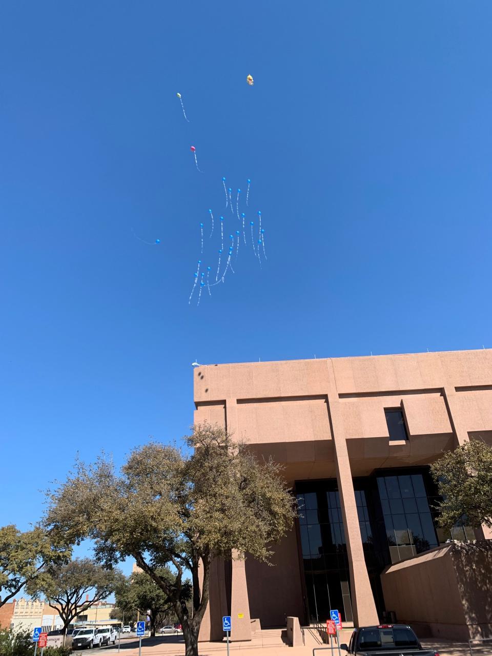 Balloons released in honor of young victim Dairess Fuller Jr. linger over the courthouse Friday, March 1, 2024.