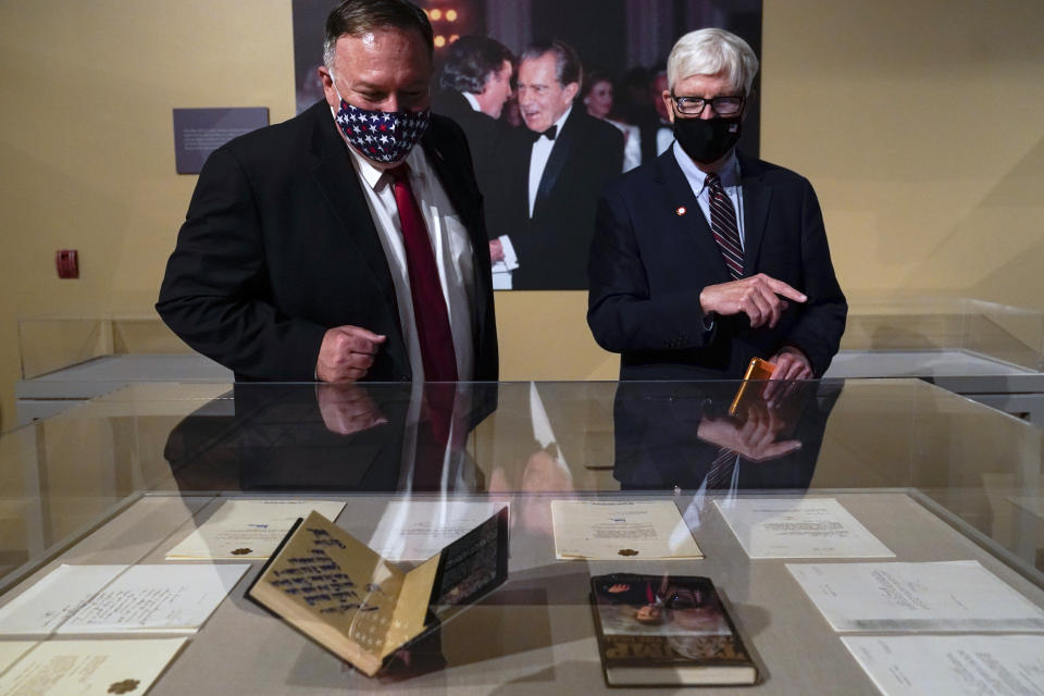 In this July 23, 2020, photo Secretary of State Mike Pompeo, left, tours an exhibit featuring letters written between Donald Trump and Richard Nixon at the Richard Nixon Presidential Library with Hugh Hewitt, president and CEO of the Nixon Foundation, in Yorba Linda, Calif. (AP Photo/Ashley Landis)