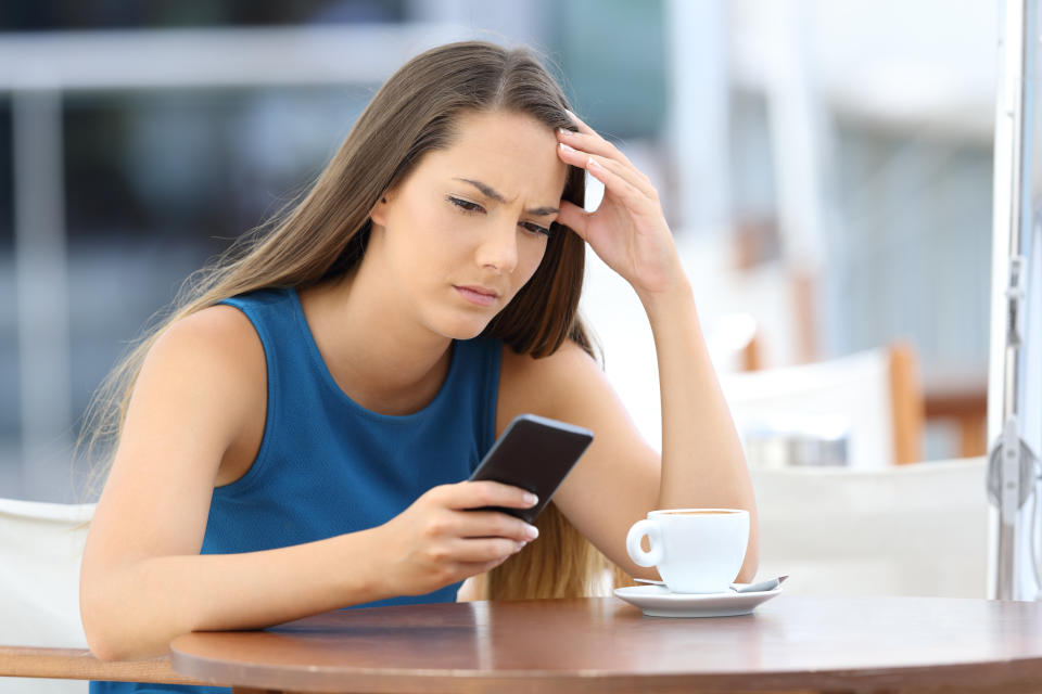 Worried woman holding phone and waiting for a call