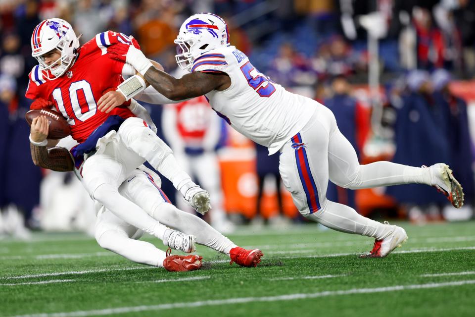 New England Patriots quarterback Mac Jones (10) is sacked by Buffalo Bills defensive end AJ Epenesa (57) and defensive end Boogie Basham (55) during the second half of an NFL football game, Thursday, Dec. 1, 2022, in Foxborough, Mass. (AP Photo/Greg M. Cooper)