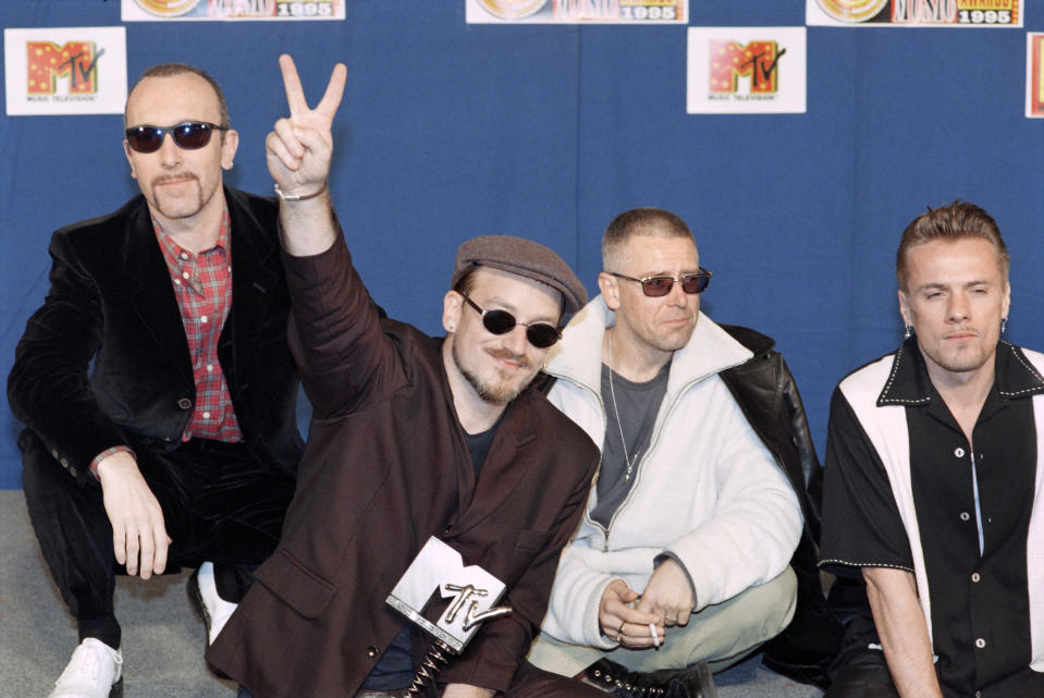 U2 wins the Europe Music Award trophy for Best Group, on November 23, 1995 in Paris. L-R guitarist The Edge, lead singer, guitarist Bono, bassist Adam Clayton and drummer Larry Mullen Junior.