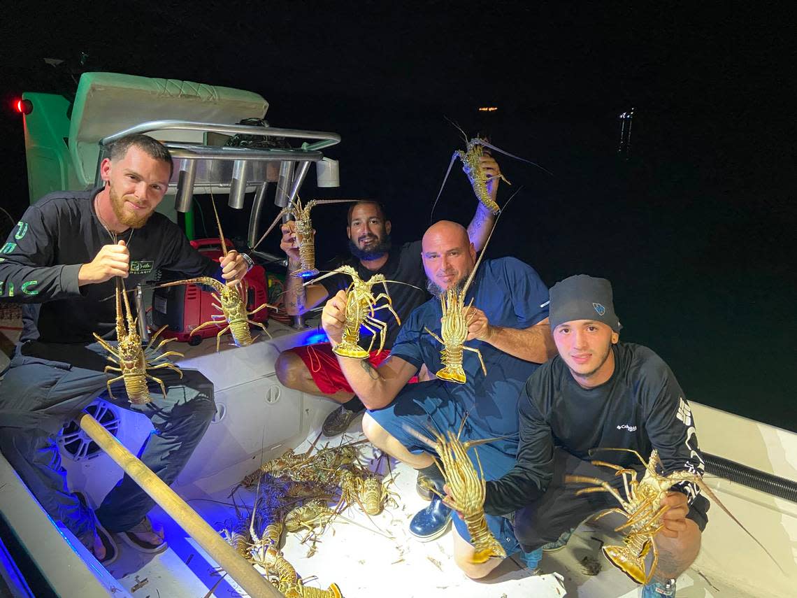 Jorge Llanos, Leo Toujaguez, Noel Pineda and Danny Marrero hold up spiny lobster they caught early Wednesday, July 28, 2021, the first day of lobster mini-season.