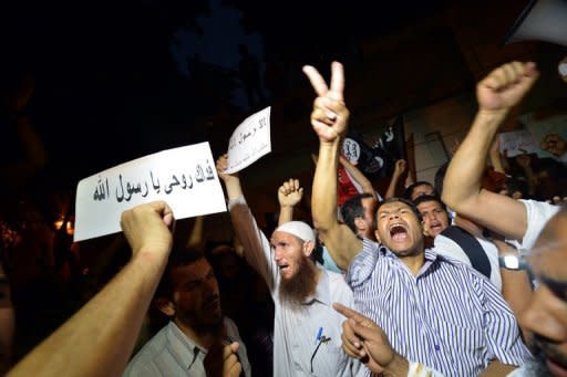 An Egyptian protester holds a sign that reads in Arabic "I sacrifice my soul for God's prophet" during a demonstration outside the US embassy in Cairo. Thousands of Egyptian demonstrators tore down the Stars and Stripes at the US embassy in Cairo on Tuesday and replaced it with an Islamic flag on the annniversary of September 11