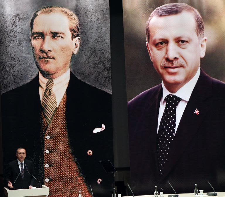 Turkish Prime Minister Recep Tayyip Erdogan delivers a speech, with behind him giant portraits of the Republic's founder Mustafa Kemal Ataturk (L) and himself, on June 25, 2014 in Ankara