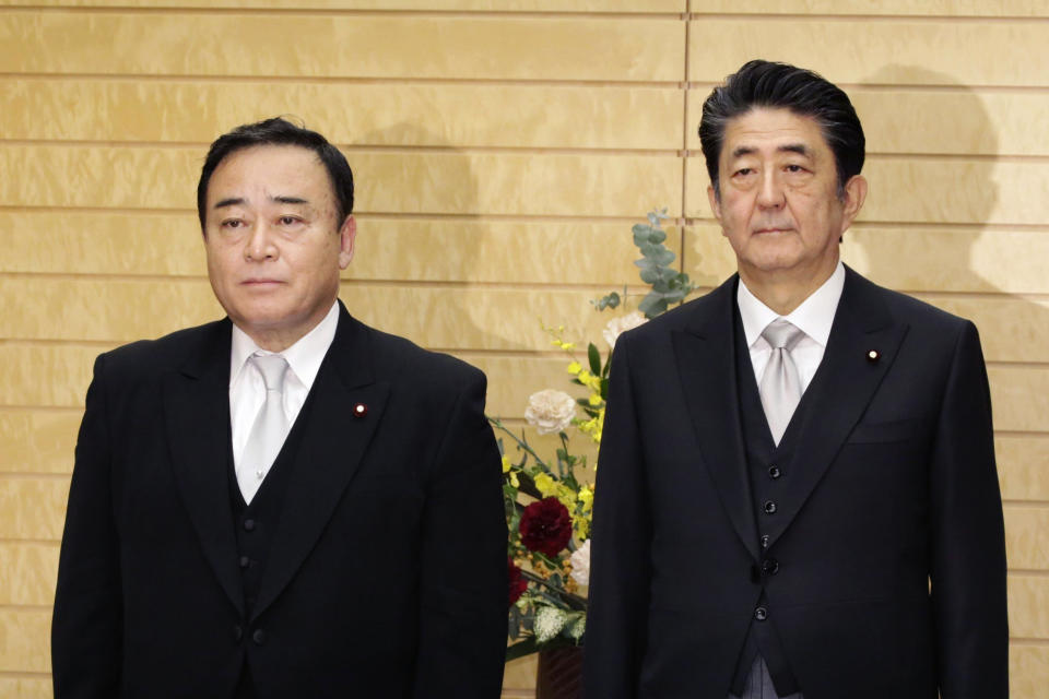 Japan's new Trade Minister Hiroshi Kajiyama, left, poses with Prime Minister Shinzo Abe for a photo at Abe's official residence in Tokyo Friday, Oct. 25, 2019. Kajiyama replaced Isshu Sugawara who resigned Friday a month into his job in a scandal over condolence money, expensive melons and other gifts allegedly offered to election supporters. Abe was quick to remove a potential damage to his Cabinet.(Toshiyuki Matsumoto/Kyodo News via AP)