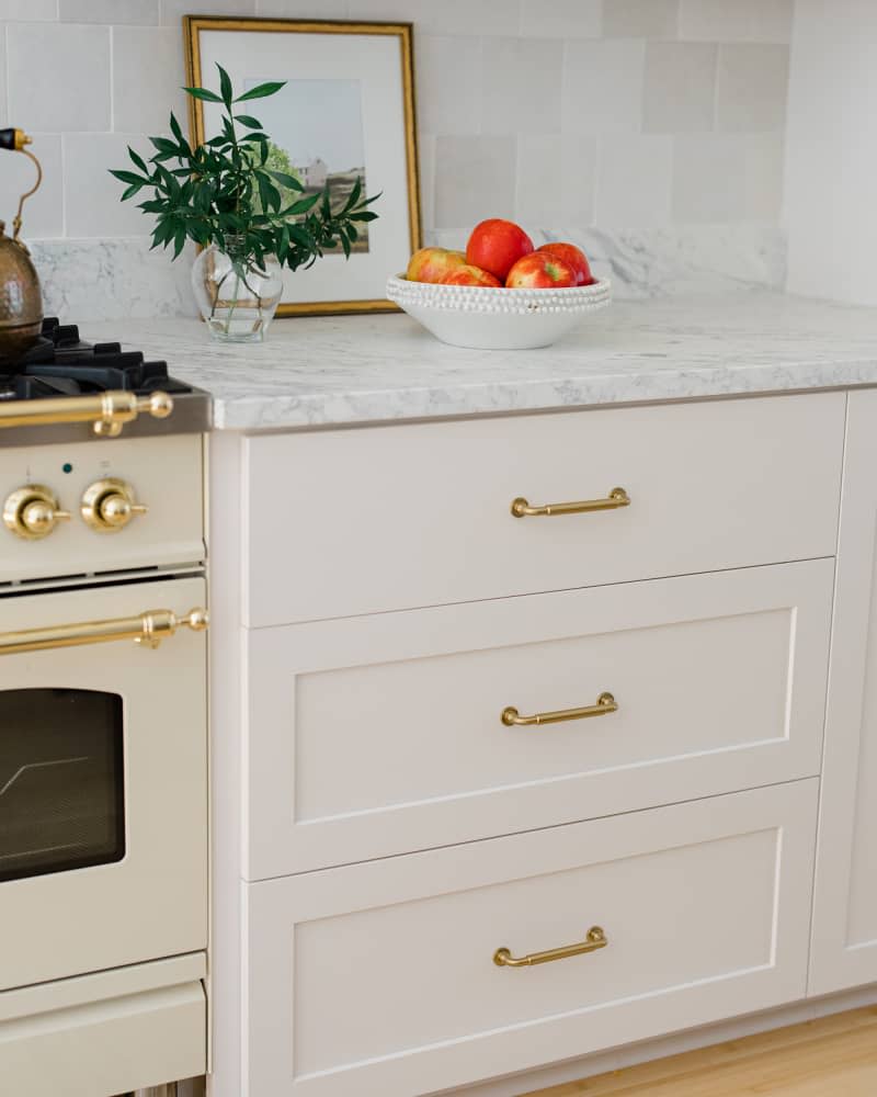 Detail of marble countertops and white drawers in remodeled kitchen