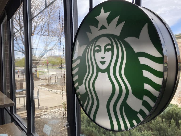 Un letrero con el logotipo de Starbucks en la ventana de una de las cafeterías de la compañía en Denver, el lunes 26 de abril de 2021. (AP Foto/David Zalubowski)