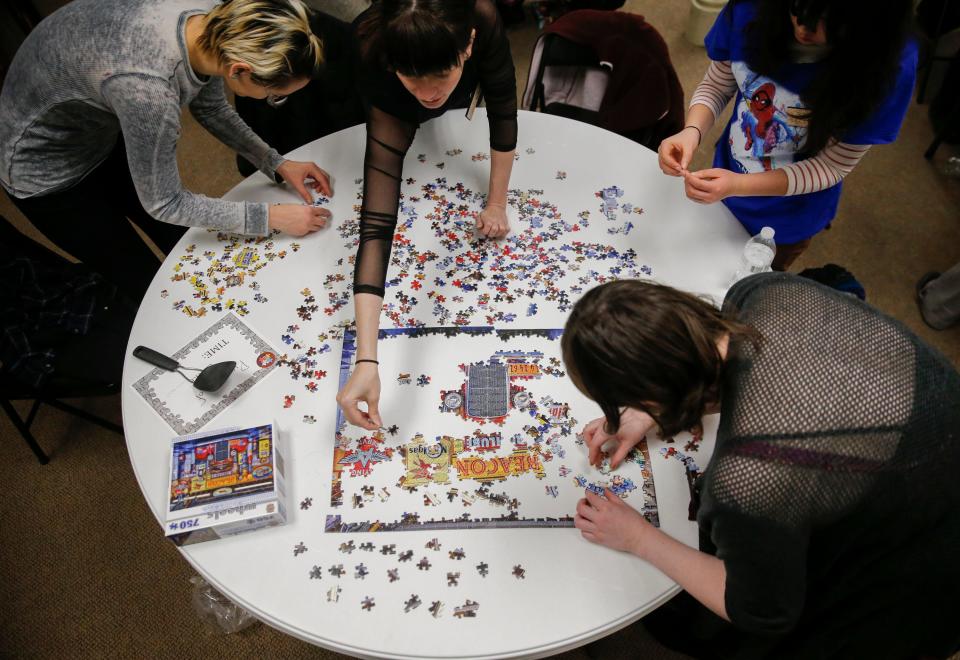 Clockwise, Dana Tzvetkov, Sarah Akemon, Nika Zulkowski and Sarah Travis open a puzzle to begin the jigsaw competition during International Puzzle Day on Jan. 26, 2019, at the Monroe County History Center in Bloomington. This year's jigsaw competition, part of PuzzleFest 2024, will be at Switchyard Park Pavilion on Jan. 28, 2024.