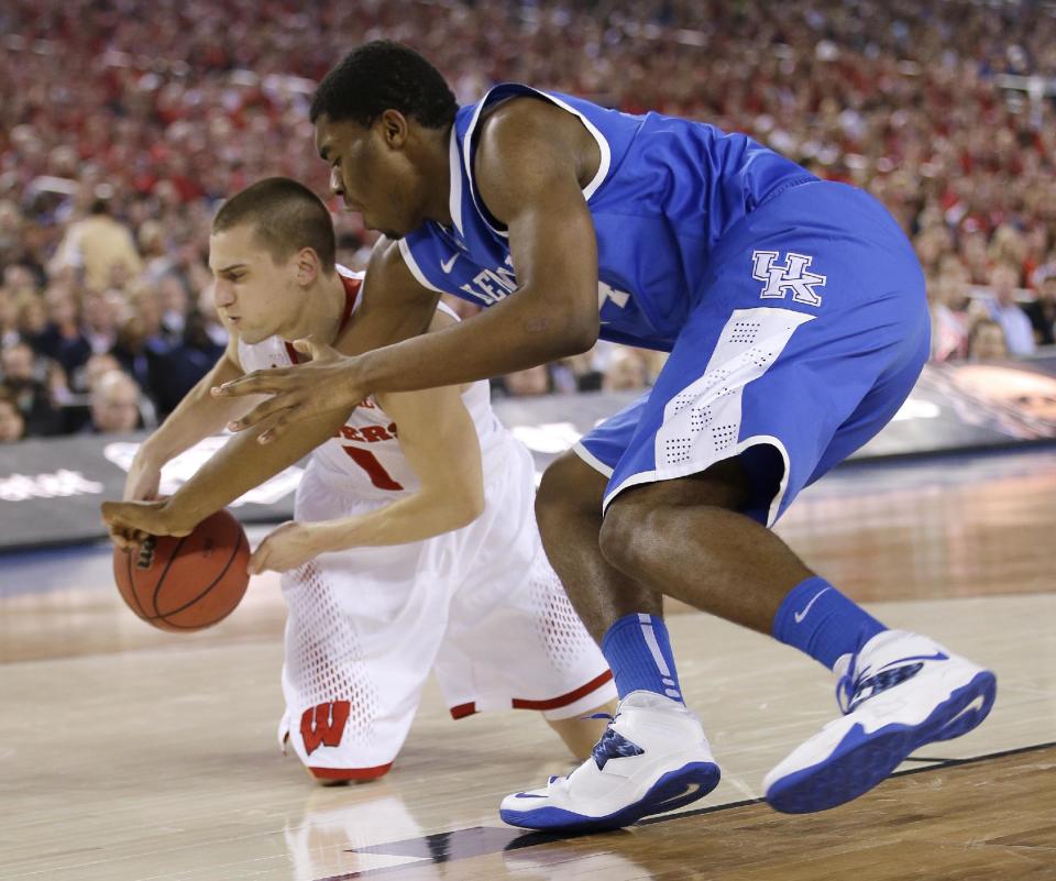Wisconsin guard Ben Brust, left, fights for a loose ball with Kentucky center Dakari Johnson during the first half of an NCAA Final Four tournament college basketball semifinal game Saturday, April 5, 2014, in Arlington, Texas. (AP Photo/David J. Phillip)