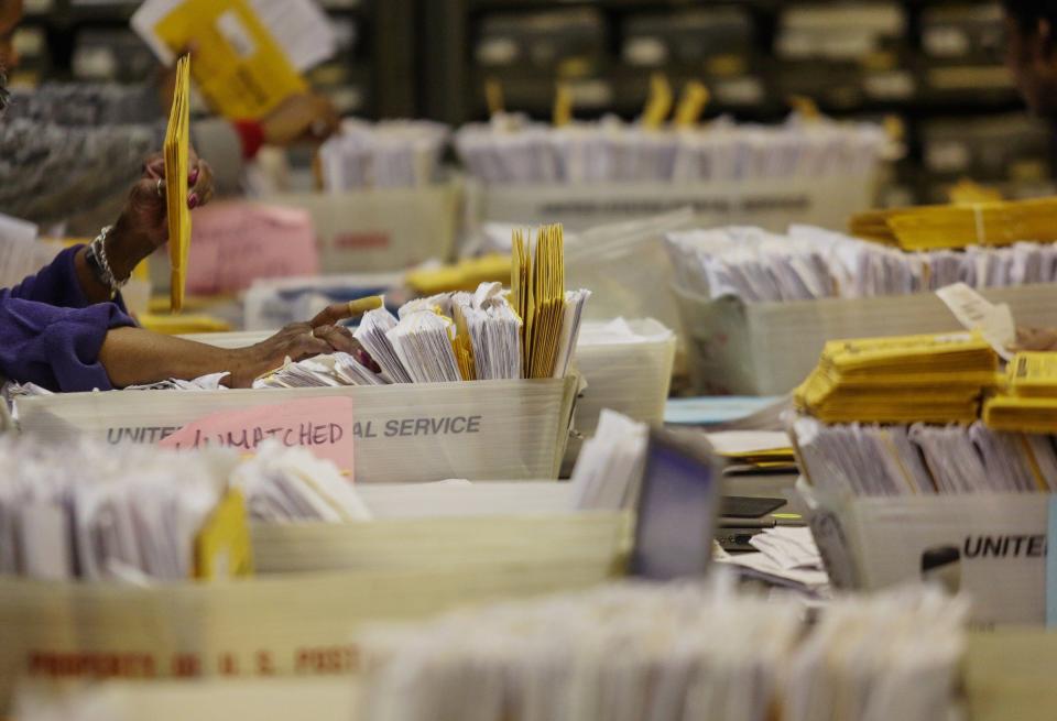 
 Workers sort through stacks of unmatched ballots while matching them with applications as they prepare absentee ballots returned on Wednesday, Oct. 29, 2014, at the City of Detroit Department of Elections in Detroit before being able to count them on Election Day.
