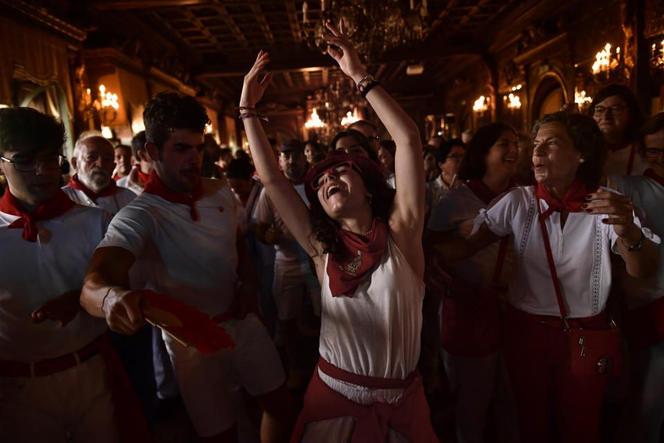 A woman dances "La Alpargata" at the end of the first day of the running of the bulls at the San Fermin festival in Pamplona, northern Spain, early Thursday, July 7, 2022. Revelers from all over the world flock to Pamplona every year to enjoy nine days of non-stop partying at the famous Pamplona running of the bulls, suspended the last two years due to the coronavirus pandemic.(AP Photo/Alvaro Barrientos)