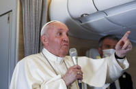 Pope Francis speaks to journalists, Monday, March 8, 2021, while flying back to The Vatican at the end of his four-day trip to Iraq where he met with different Christian communities and Shiite revered cleric Grand Ayatollah Ali al-Sistani. At right pope's spokesperson Matteo Bruni. (AP Photo/Yara Nardi, pool)