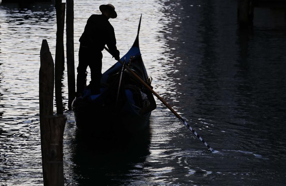 A gondolier rows in a canal near St. Mark's Square in Venice