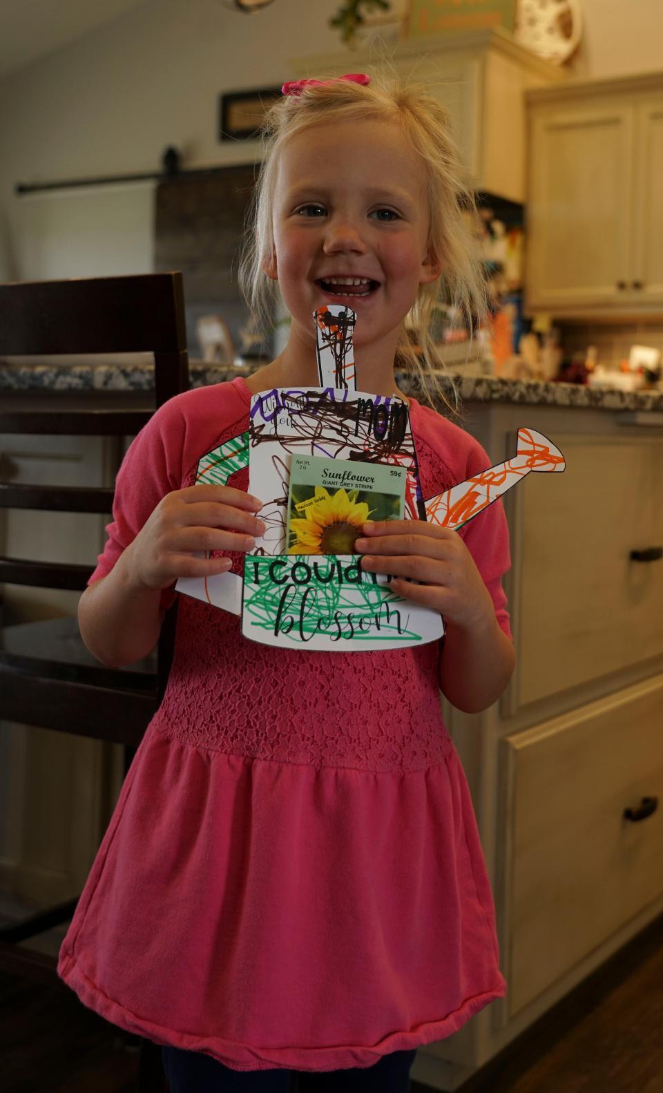 Four-year-old Nora Matthiesen stands with a flower pot that she decorated for Mother's Day.